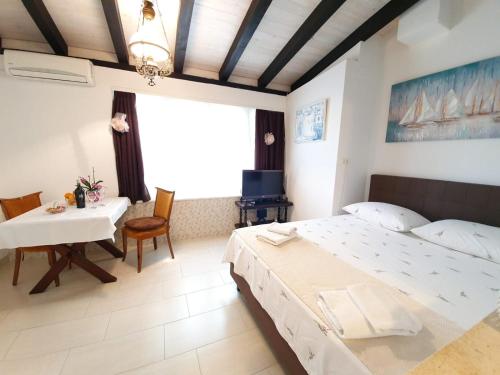 een slaapkamer met een groot bed en een tafel bij Apartments Dabar in Dubrovnik