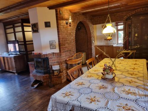 a dining room with a table and a brick wall at Szydlukówka in Janów Podlaski