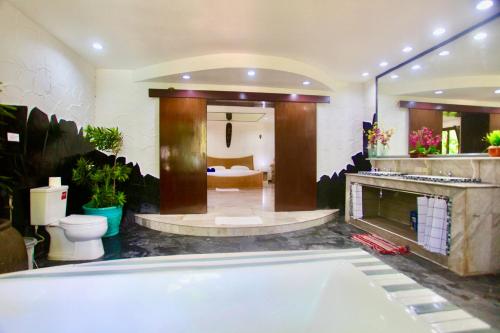 a large bathroom with a tub and a fireplace at Sunshine Villa and Diving School . in Ban Sakhu