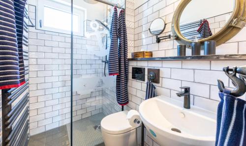 a bathroom with a toilet and a sink and a mirror at Terrassen-Fewo-Ankerplatz-direkt-am-Ostseestrand in Kronsgaard