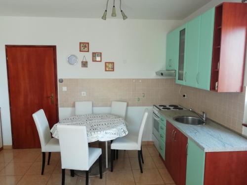 a kitchen with a table and chairs and a sink at Apartment Vesna Vabriga in Vabriga
