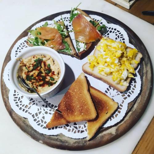 a plate of food with toast and a bowl of salad at la corte dei cerri in Spervara