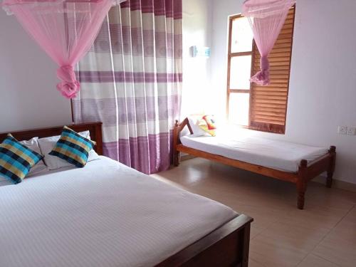 a bedroom with two beds and a window at Saubagya Residence - Air Port View in Anuradhapura