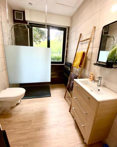 une salle de bain avec un lavabo et des toilettes et une fenêtre dans l'établissement Stud West, à Lorient