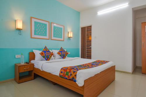 a bedroom with a bed and a blue wall at FabHotel Aakiyo in Pune