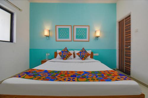 1 dormitorio con 1 cama grande y paredes azules en FabHotel Aakiyo en Pune
