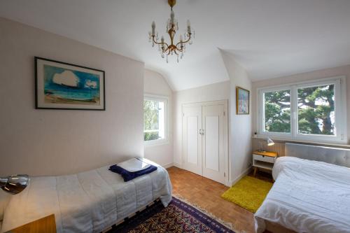 ein Schlafzimmer mit zwei Betten und einem Kronleuchter in der Unterkunft Ty Maine in Carantec