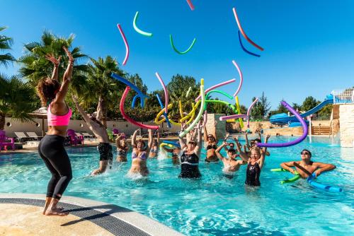 un groupe de personnes dans une piscine jouant dans l'eau dans l'établissement Camping maeva Club Les Préveils, à La Tranche-sur-Mer