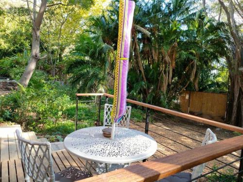 a table and chairs on a wooden deck with a table and a table at ZenCapeTown Forest Retreat in Cape Town