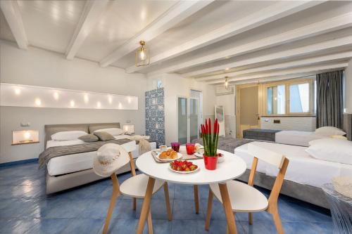 - une chambre avec un lit, une table et des chaises dans l'établissement Albert Rooms & Breakfast, à San Vito Lo Capo