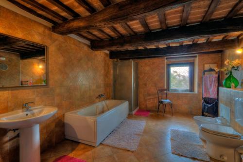 y baño con 2 lavabos, bañera y lavamanos. en Castello Montesasso, en Mercato Saraceno