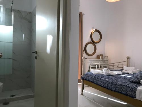a bedroom with a bed with a shower and a mirror at Sea view pension Violeta room1 for two in Parikia