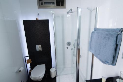 a white bathroom with a shower and a toilet at Prestige Room in Prestige location Bahai's Garden in Haifa
