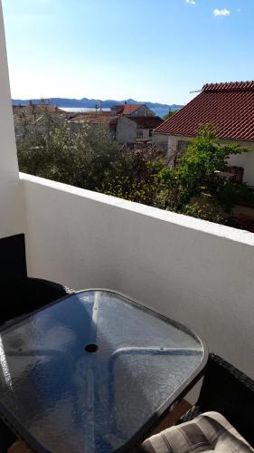 a glass table on a balcony with a view at Apartments Mira in Bibinje