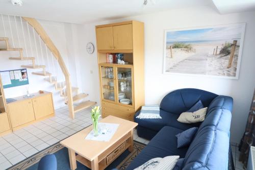 een woonkamer met een blauwe bank en een tafel bij Appartmenthaus Nordlicht in Cuxhaven