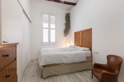 ein Schlafzimmer mit einem Bett und einem Stuhl in der Unterkunft Monlau 12 in Barcelona
