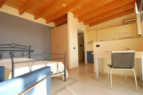 Cette chambre comprend deux lits, une table et un bureau. dans l'établissement Residence & Suites Solaf, à Bonate di Sopra