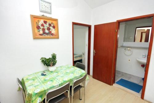 een eetkamer met een tafel en een wastafel bij Apartments Let-5m from sea in Sukošan