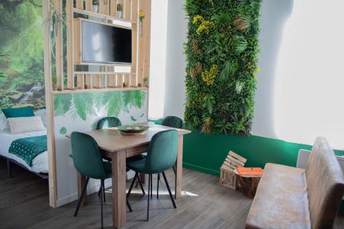 une salle à manger avec une table et des chaises vertes dans l'établissement * Les Suites aux Étoiles *, à Clermont-Ferrand