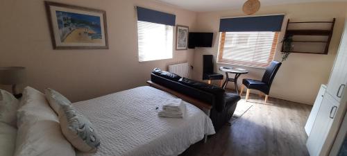 a bedroom with a bed and a couch and a table at Farriers in Dartmouth