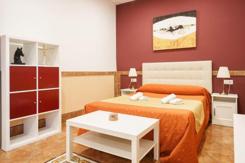 a bedroom with two beds and a table at Hotel Carlos V Jerez by Vivere Stays in Jerez de la Frontera