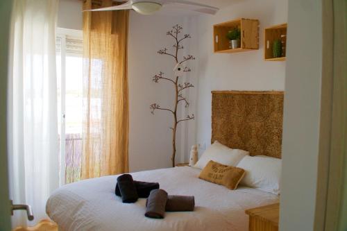 a bedroom with a bed with two towels on it at "soñaC soL" in Los Caños de Meca