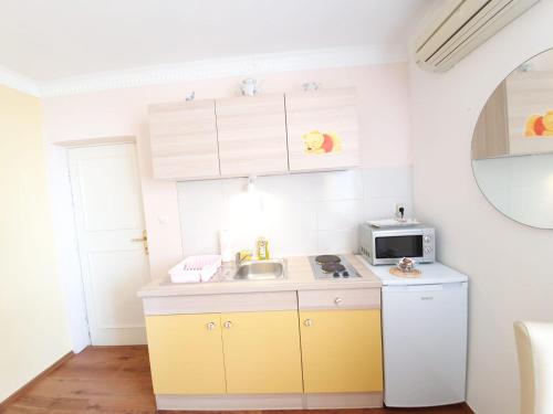 a small kitchen with a sink and a microwave at Apartments Dabar in Dubrovnik