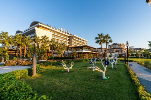 a park in front of a building with palm trees at Adenya Hotel & Resort Halal All Inclusive in Avsallar