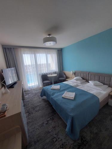 a bedroom with a large bed and a blue wall at Apartament Nad Parsętą in Kołobrzeg
