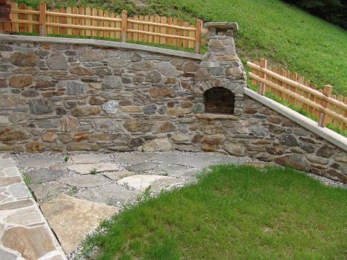 a stone wall with a gate and a fence at Grossgasteigerhof in Selva dei Molini