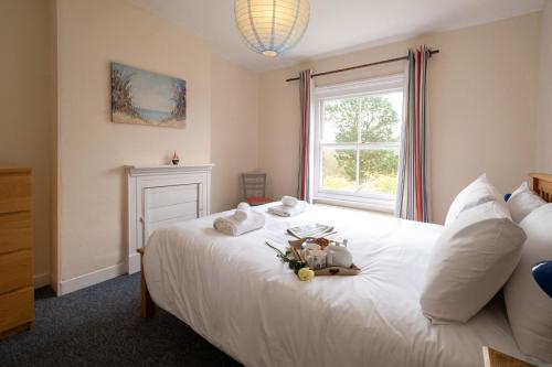 a bedroom with a white bed with flowers on it at Mere Cottage - Aldeburgh Coastal Cottages in Thorpeness