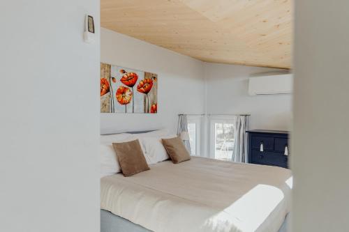 a white bedroom with a large bed in it at La Rosa Gialla Bio Apartments & rooms in Barolo