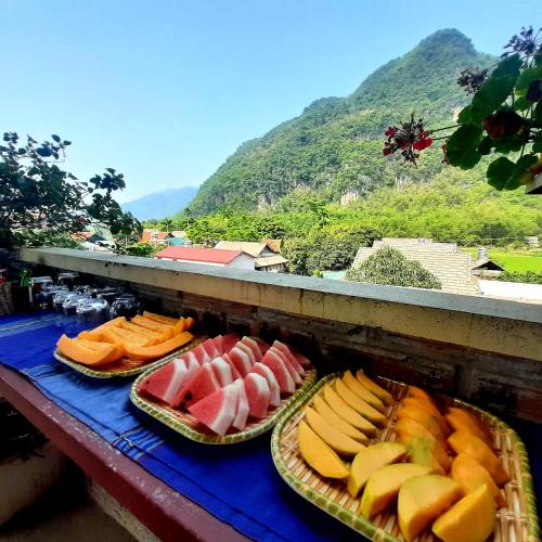 three plates of fruit on a table with a mountain at Hakuna Matata homestay Mai Châu in Mai Chau