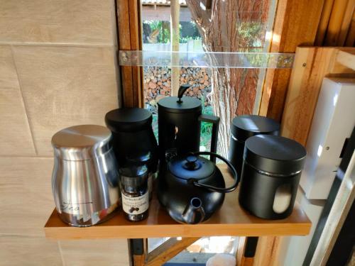 a shelf with a group of coffee pots and pans at ZenCapeTown Forest Retreat in Cape Town