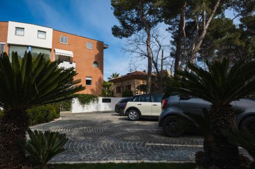 two cars parked in a parking lot in front of a building at Luxury B&B La Riserva Dannunziana in Pescara
