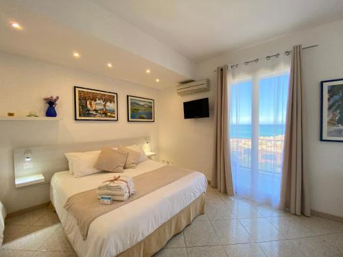 ein Schlafzimmer mit einem Bett und einem großen Fenster in der Unterkunft Ma&Mi Guest House in Cefalú