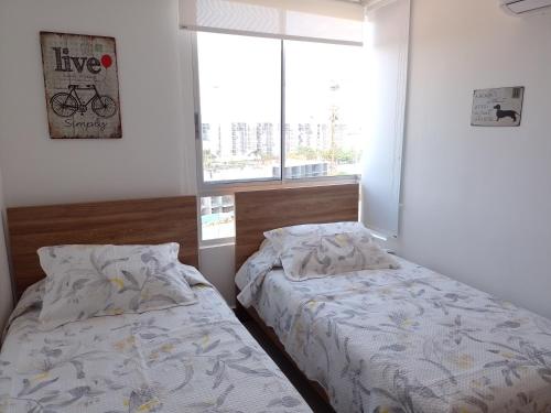 - 2 lits installés l'un à côté de l'autre dans une chambre dans l'établissement Apartamento ideal para disfrutar Vacaciones en Ricaurte Cund, à Ricaurte