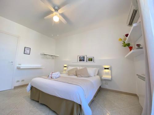 a bedroom with a white bed and white walls at Ma&Mi Guest House in Cefalù