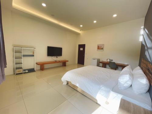 a bedroom with a bed and a flat screen tv at City of Trees B&B in Sanxia