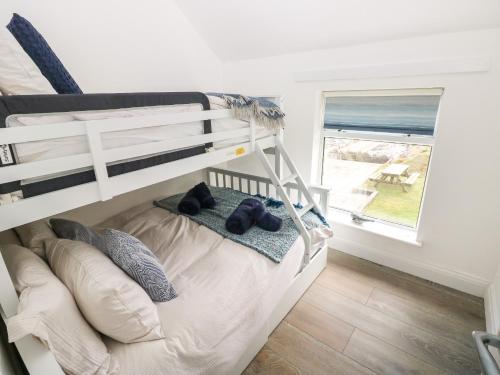ein Etagenbett mit zwei Teddybären darauf in einem Schlafzimmer in der Unterkunft 2 Salt Cottage in Swansea