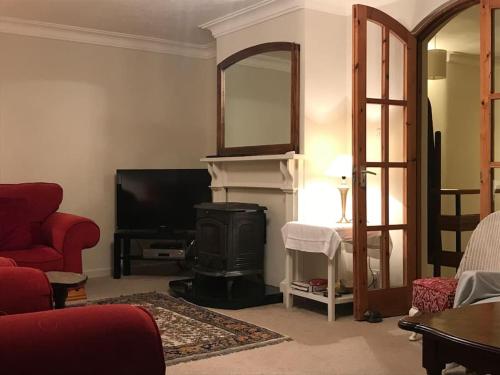 a living room with a fireplace and a television at Four Winds, Ross, Killala. in Killala