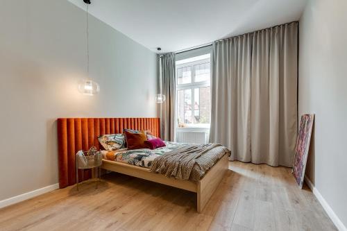 een slaapkamer met een bed voor een raam bij Jan III Sobieski - Luksusowy apartament S prywatny darmowy parking in Gliwice