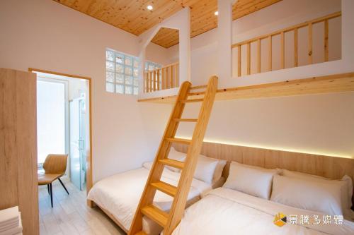 1 dormitorio con litera y escalera en 有貓匿鄉村咖啡館民宿 en Sanxing