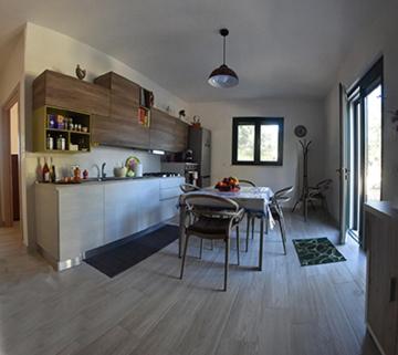 una cucina e una sala da pranzo con tavolo e sedie di Casa Polinisso a Carovigno