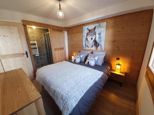 - une chambre avec un lit avec une photo de loup dans l'établissement Le Repaire des Loups - Appart neuf 12 pers 4 chambres - location à la semaine, à Saint-François-Longchamp