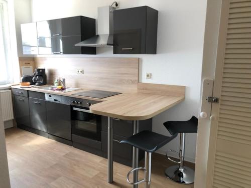 a kitchen with a wooden counter and black appliances at Ferienwohnung Spremberg-City II in Spremberg