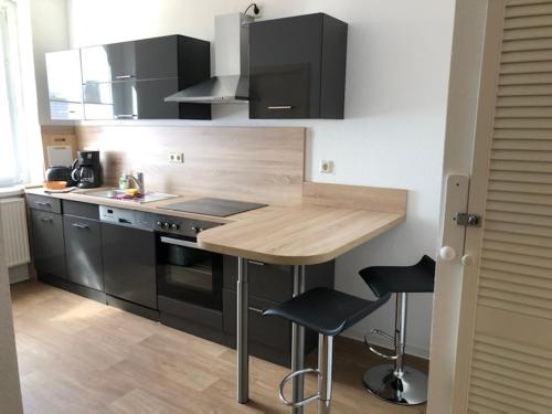 una cucina con bancone in legno ed elettrodomestici neri di Ferienwohnung Spremberg-City II a Spremberg