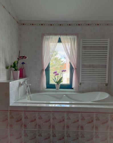 a bath tub in a bathroom with a window at Cozy rooms in wine town - Modra in Modra