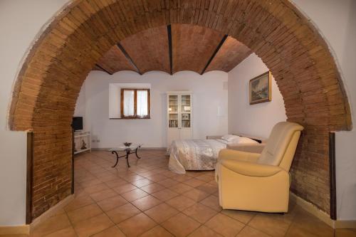 una camera con arco, letto e sedia di Enchanting Flat with Patio in Abbadia a Isola a Monteriggioni