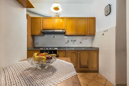a kitchen with a bowl of fruit on a table at Enchanting Flat with Patio in Abbadia a Isola in Monteriggioni